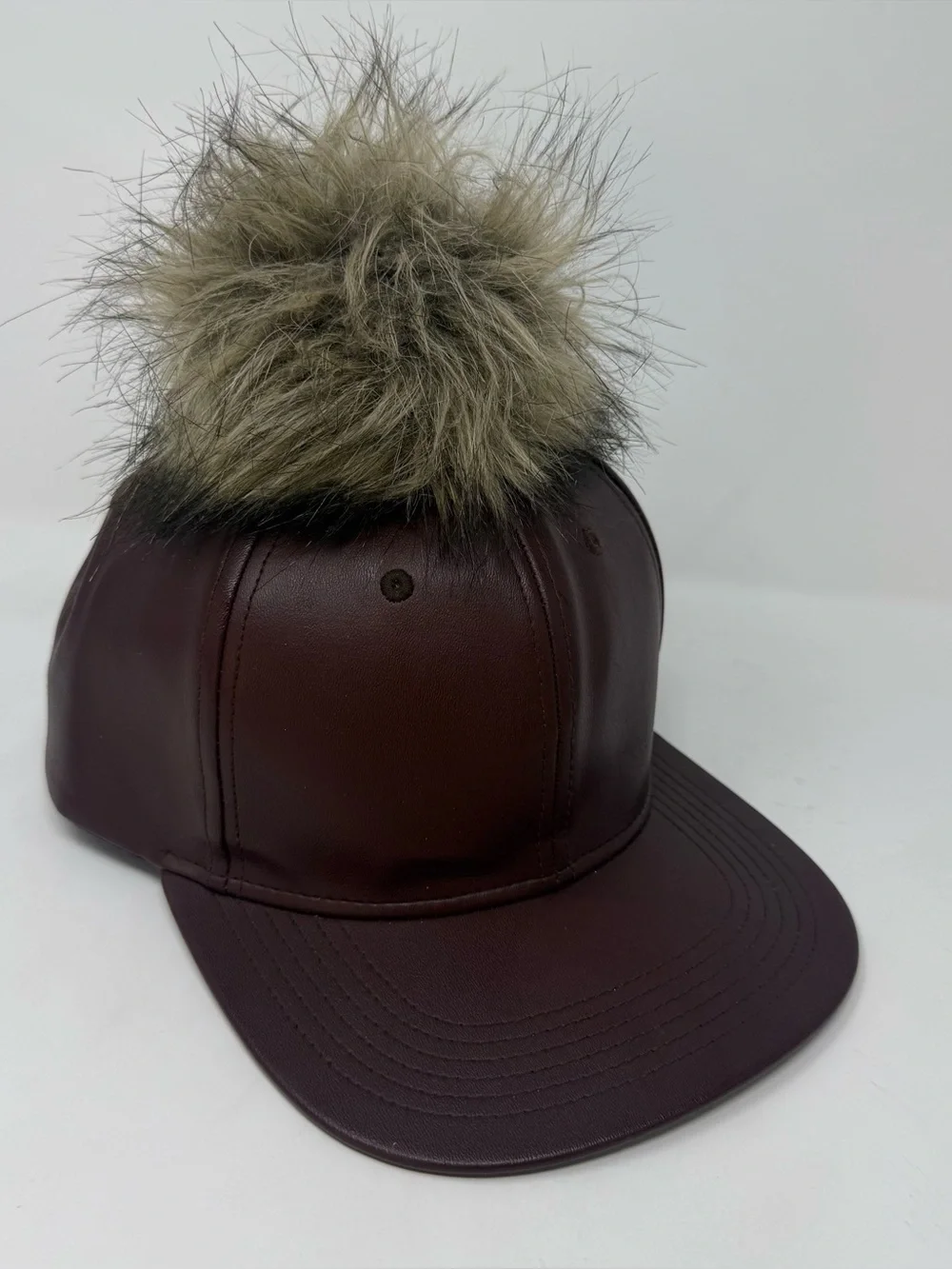 faux leather baseball cap by Premium Hatco features a faux fur pompom